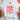 White t-shirt with 'All American Girl' design on a light surface with decorative items.