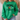 A woman wearing a bright green crewneck sweatshirt with a black and white football graphic and text on the front, paired with light blue jeans in a cozy indoor setting.