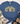 A blue short-sleeve graphic T-shirt laid flat on a white wood background, styled with a striped knit blanket, jeans, and tan lace-up boots. The shirt has a large decorative floral and bow graphic spelling the word “GRACE.