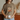 Person wearing a brown t-shirt with a floral design and text, holding a mug.