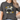 Person wearing a dark gray t-shirt with floral design and text