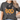A woman wearing a dark heather gray t-shirt with a graphic that reads 'but GOD' in black and orange lettering, decorated with small pink flowers.