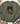 An olive green crewneck sweatshirt featuring a graphic of a pumpkin with a camouflage pattern, a black bow, and a gold outline, styled in a flat lay with a hat, jeans, and a plaid scarf.