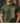 Person wearing a green t-shirt with camouflage text design against a wooden background