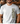 Man wearing a white t-shirt with 'CHISEN' printed in camouflage text, standing in a blurred indoor setting.
