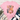 A pink short-sleeve graphic T-shirt laid flat on a white wood background, styled with blue jeans, white sneakers, a fringed throw blanket, and greenery. The shirt has a colorful patchwork-style 'LOVE LIKE DOLLY' text graphic with butterflies.