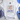 White t-shirt with colorful mountain design and 'Faith Moves Mountains' text, surrounded by accessories on a light surface.