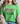 A woman wearing a bright green graphic t-shirt with the words 'FAITH OVER FEAR' printed on the front. The word 'FAITH' is filled with a colorful floral pattern, while 'OVER FEAR' is in black script.