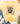 A pale yellow graphic T-shirt laid flat on a white wood surface, styled with blue jeans, white sneakers, a straw hat, and eucalyptus stems. The shirt has a large raccoon illustration with a leopard-print bow, autumn leaves, pumpkins, and the text 'feral girl autumn'.