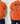 Orange t-shirt with 'Fishers of Men' design on a white brick wall background