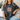Person wearing a black t-shirt with a colorful flower design and text.