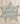 A beige canvas tote bag with brown leather handles, featuring a large star graphic on the front with the phrase 'God is good all the time' in script and patterned star details, set on a wooden surface against a white wall with eucalyptus branches.