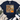 A navy blue graphic t-shirt with a distressed autumn design featuring the text 'God is Good ALL THE TIME', a pumpkin, and flowers. The shirt is styled in a flat-lay arrangement with a knotted hem, paired with distressed blue jeans, white sneakers, and a fringed throw blanket on a white wood background.
