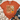 An orange short-sleeve graphic T-shirt laid flat on a white wood surface, styled with a knit blanket, jeans, and tan ankle boots. The shirt has a large fall-themed front print reading “God is Good All the Time” with flowers and a pumpkin.