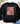 A black crewneck sweatshirt with a colorful 'GOBBLE GOBBLE' graphic printed on the front, styled in a flat lay with jeans, shoes, and eucalyptus leaves.