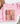 A folded light pink sweatshirt with a graphic reading 'GOBBLE GOBBLE' in multicolored patterned letters, styled on a white surface with a tan hat and dried flowers nearby.