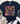 A navy blue graphic t-shirt with a colorful floral design and the text 'Happiness is found FROM WITHIN' in the center. The t-shirt is styled in a flat-lay arrangement with distressed blue jeans, white sneakers, a fringed throw blanket, and green leaves on a white wood background.
