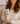 Woman holding a pink water bottle with religious design and text.