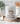 White mug with 'Powered by Jesus & Coffee' design on a kitchen counter with coffee beans.