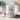 White mug with 'Powered by Jesus & Coffee' design on a kitchen counter with coffee beans.