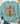 A mint green crewneck sweatshirt with a Christmas-themed graphic print, styled in a flat lay with blue jeans, white sneakers, a straw hat, and eucalyptus on a white wood background.