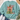 A mint green crewneck sweatshirt with a Christmas-themed graphic print, styled in a flat lay with blue jeans, white sneakers, a straw hat, and eucalyptus on a white wood background.