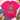 A bright pink graphic T-shirt laid flat on a white wood surface, styled with blue jeans, tan loafers, a straw hat, and greenery. The shirt has a large front print of a frog riding a bicycle with the text “CHOOSE KINDNESS BE THE GOOD ONE leave your worries BEHIND.