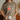 Person wearing a brown t-shirt with a turtle and flower design, holding a mug.