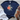 Navy blue t-shirt with turtle and flower design, paired with white jeans and brown sandals on a wooden surface.