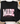 A black long-sleeve crewneck sweatshirt laid flat on a white wood surface, featuring the phrase 'MADE for more EPHESIANS 2:10' in decorative pink and floral lettering. The sweatshirt is styled with jeans, a coffee cup, a plaid blanket, and flowers around it.
