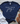 Navy blue t-shirt with 'Made from Joy' text on a wooden surface with white jeans and sandals.