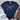 Navy blue t-shirt with 'Made from Joy' text on a wooden surface with white jeans and sandals.