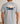 Gray t-shirt with a graphic of a man and his dog  in a boat on the back, set against a plain background.