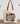 A canvas tote bag with brown leather handles sits on a wooden table against a white wall, decorated with eucalyptus branches. The bag features a large graphic print with a mountain illustration and the text 'MOUNTAIN MOVER' and 'MATTHEW 11:20-27'.
