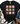 A black short-sleeve graphic T-shirt laid flat on a white wood background, styled with a cream knit blanket, blue jeans, and brown lace-up boots. The shirt features a grid of nine cute cartoon pigs in different colors and patterns on the front.