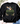 A black crewneck sweatshirt laid flat on a light wood surface, featuring a colorful graphic of mallards, clovers, and the text 'I will praise Him in every season' from Philippians 4:13. Styled with eucalyptus leaves, flowers, a pair of white sneakers, and blue jeans.