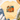 A pale yellow short-sleeve T-shirt laid flat on a white wood surface, styled with blue jeans, white sneakers, a straw hat, and eucalyptus. The shirt has a large autumn pumpkin graphic in orange, teal, brown, purple, and green tones on the front.