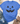 A heather blue short-sleeve T-shirt with a distressed black jack-o'-lantern face graphic, styled in a flat lay with blue jeans, brown ankle boots, a straw hat, and small green leaves on a cream textured background.