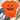 Bright orange short-sleeve T-shirt with a large distressed black jack-o'-lantern face graphic, styled in a flat lay with blue jeans, white sneakers, a straw hat, eucalyptus stems, and white flowers on a white wood background.