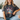 Woman wearing a t-shirt with patriotic design sitting on a couch.
