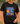 Person wearing a black t-shirt with 'Jesus and Softball' design on a baseball field.