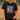 Person wearing a black t-shirt with 'Jesus and Softball' design on a baseball field.