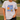 Person wearing a t-shirt with 'Jesus Loves Softball' design on a baseball field.