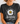 Person wearing a black t-shirt with a daisy graphic and text.