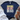 Navy blue t-shirt with 'Sunshine on My Mind' text, paired with white jeans and brown sandals on a wooden surface.