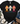 A black short-sleeve graphic T-shirt laid flat on a white wood background, styled with a cream knit blanket, eucalyptus stems, blue jeans, and brown lace-up boots. The shirt features three colorful decorative crosses in orange, pink, and aqua, with the words 'Grateful Thankful Blessed' and 'GOD IS FAITHFUL IN EVERY SEASON' printed below.