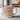 Pink mug with motivational quote and cross design on a marble surface