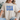 Person wearing a beige t-shirt with 'USA' printed in blue and white stars.