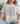 Person wearing a beige t-shirt with 'USA' text design.