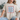 Person wearing a beige t-shirt with 'USA' text design.